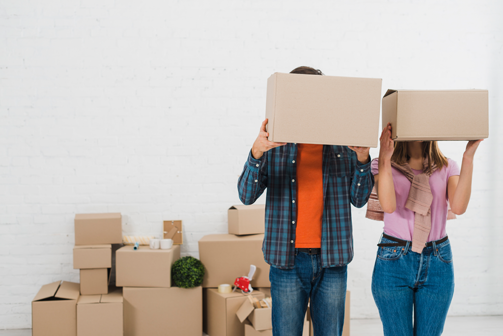 A happy couple surrounded by moving boxes.