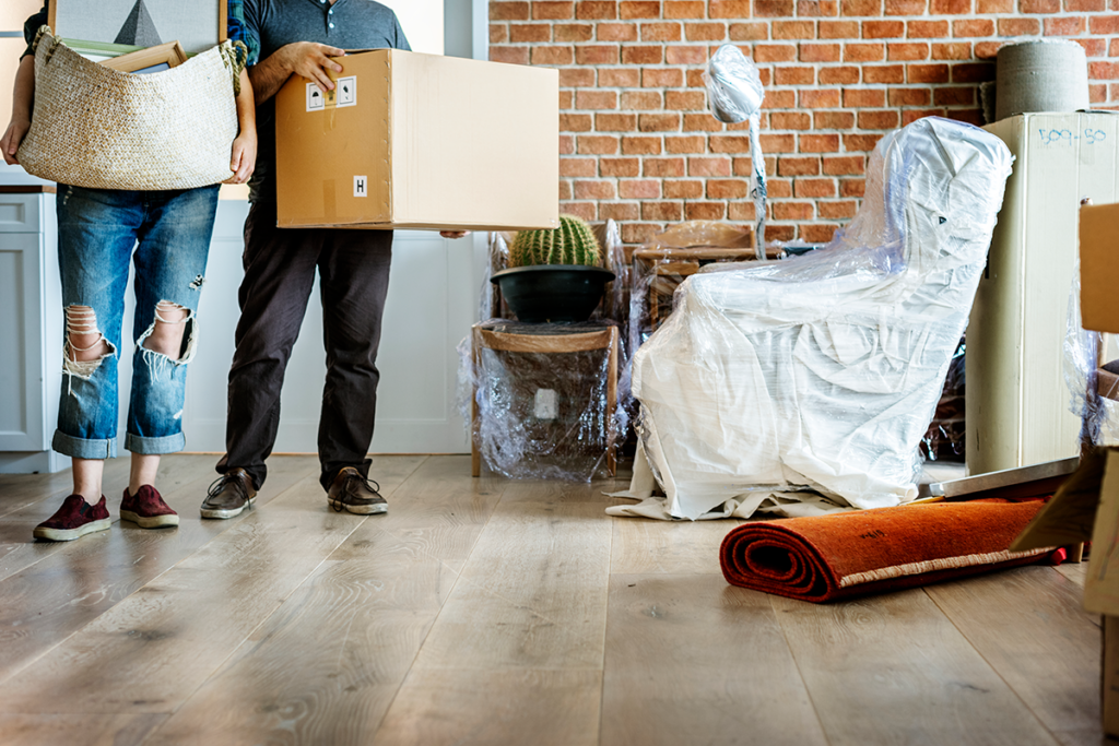 Individual standing amidst a cluttered and chaotic space with scattered moving boxes, illustrating the consequences of not planning ahead.