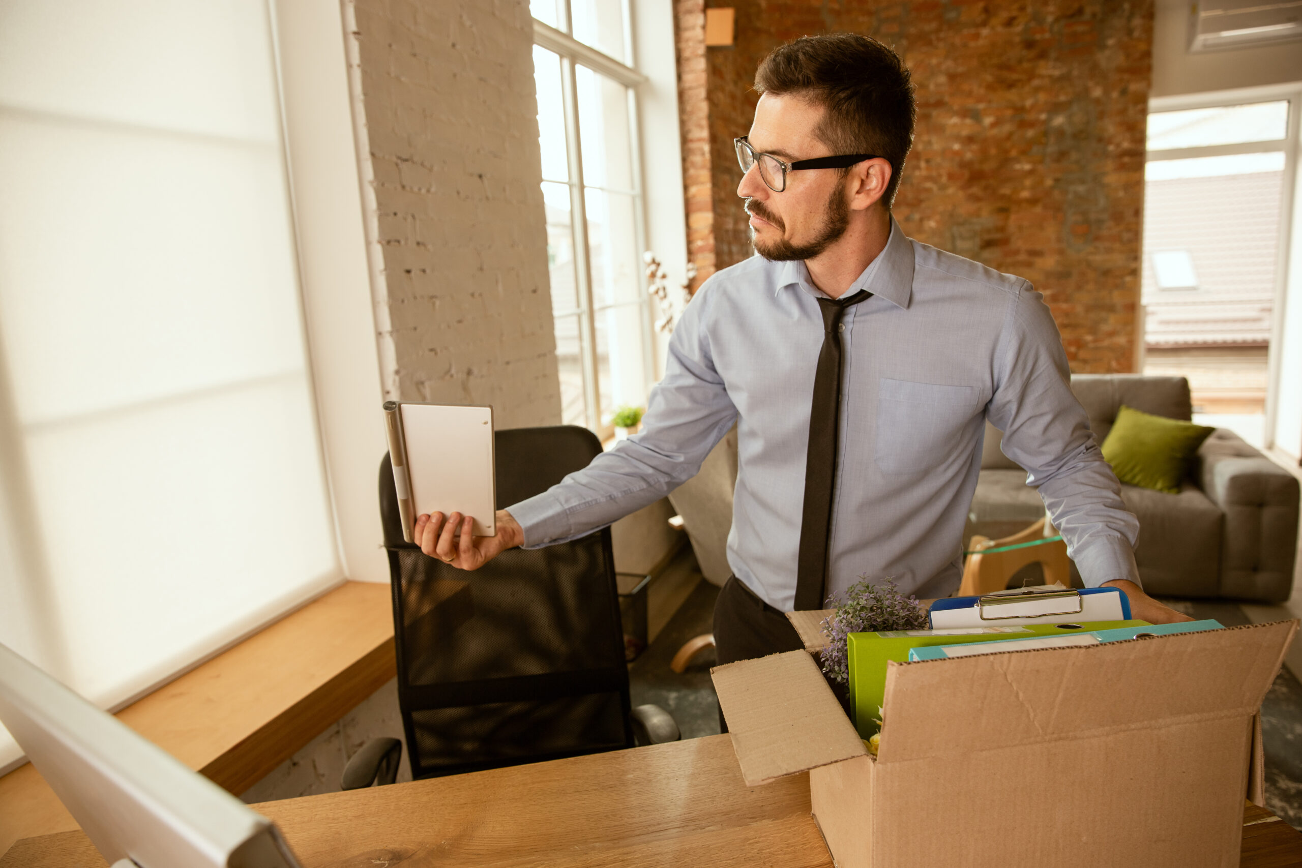 Employees unpacking office supplies and setting up their new workspace after a successful move.