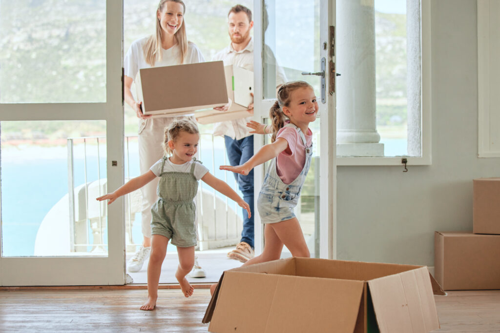 Children, running and family moving in home, new apartment and real estate investment or property mortgage. Parents, boxes and girl kids with playing airplane in doorway, entrance and happiness