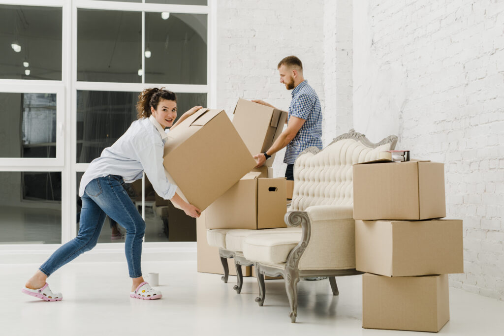 A couple packing their belongings using free moving boxes to reduce moving costs.